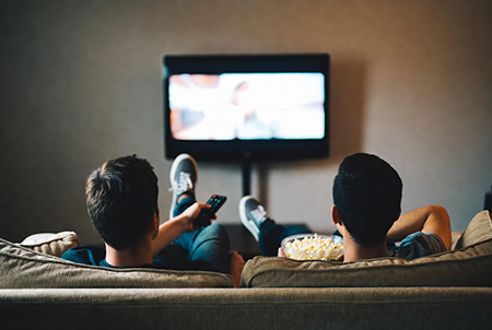two roommates sitting on a couch watching television image created with Grok AI
